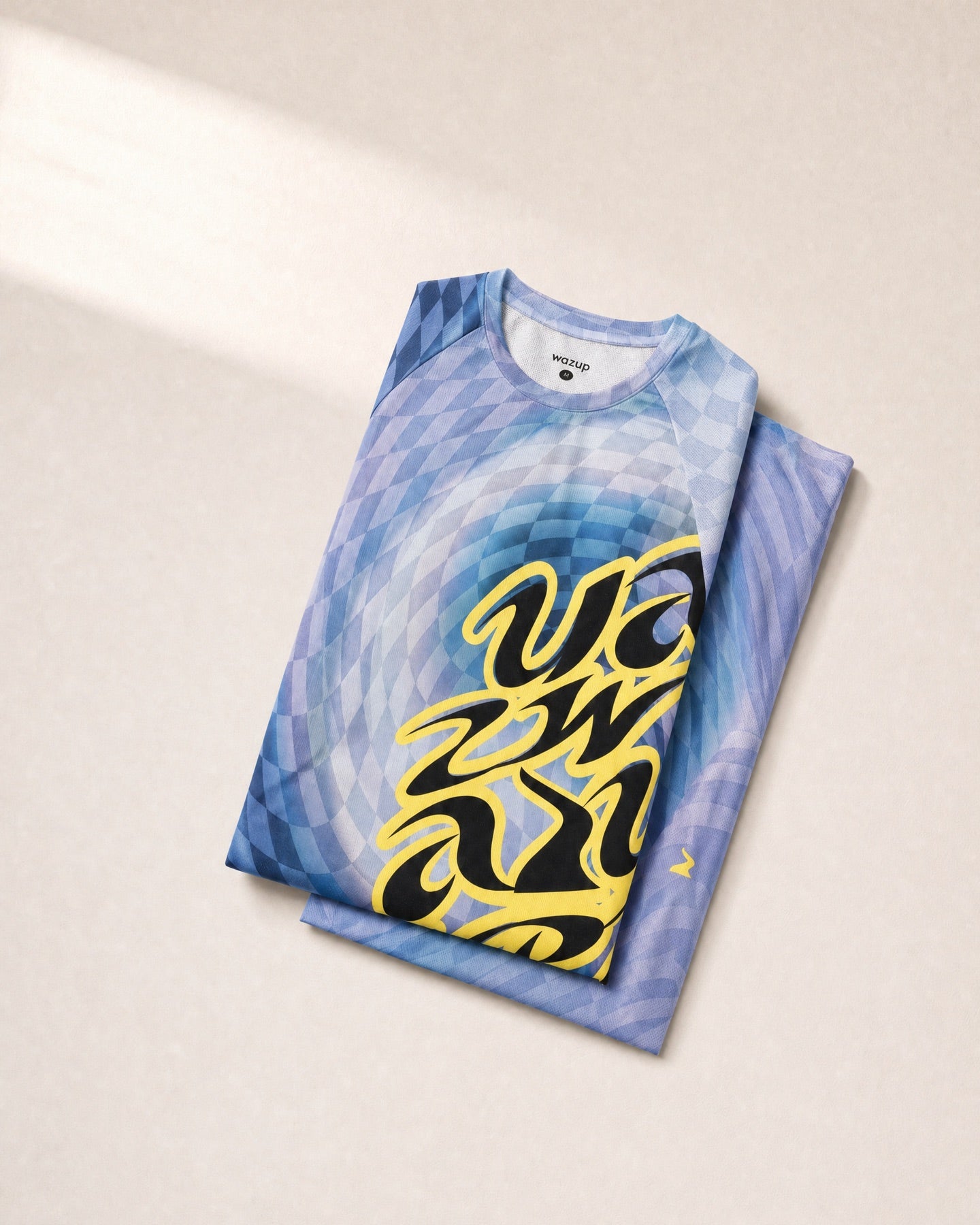 Big Bold Tee folded on the approved sunlit product-shot background